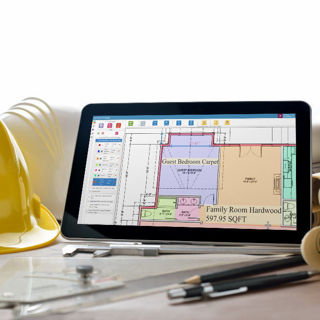Building plans shown on a tablet screen on a desk with drafting tools