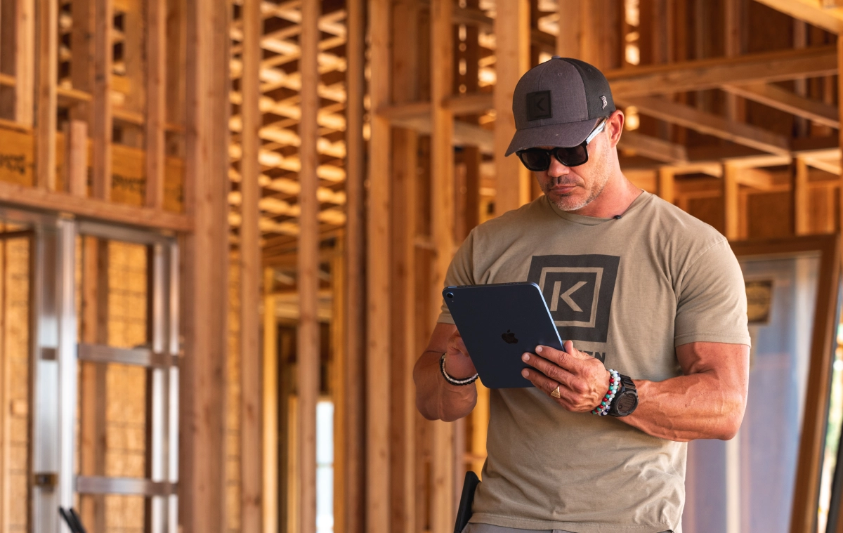 A builder on a job sire looking at an iPad