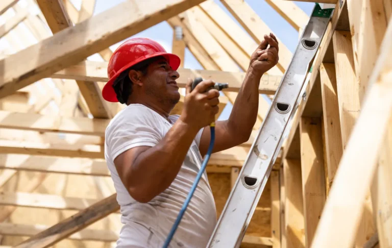 A man on a ladder with a drill