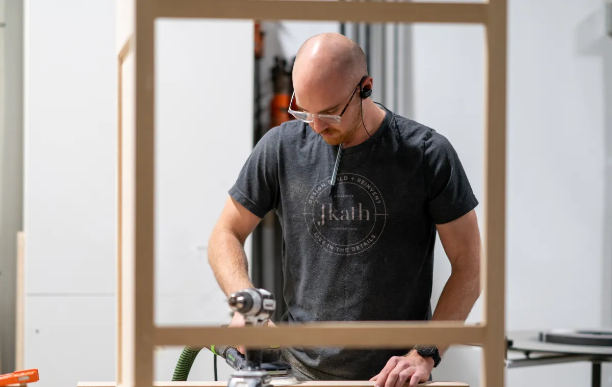 Team member from JKath working o a wood frame